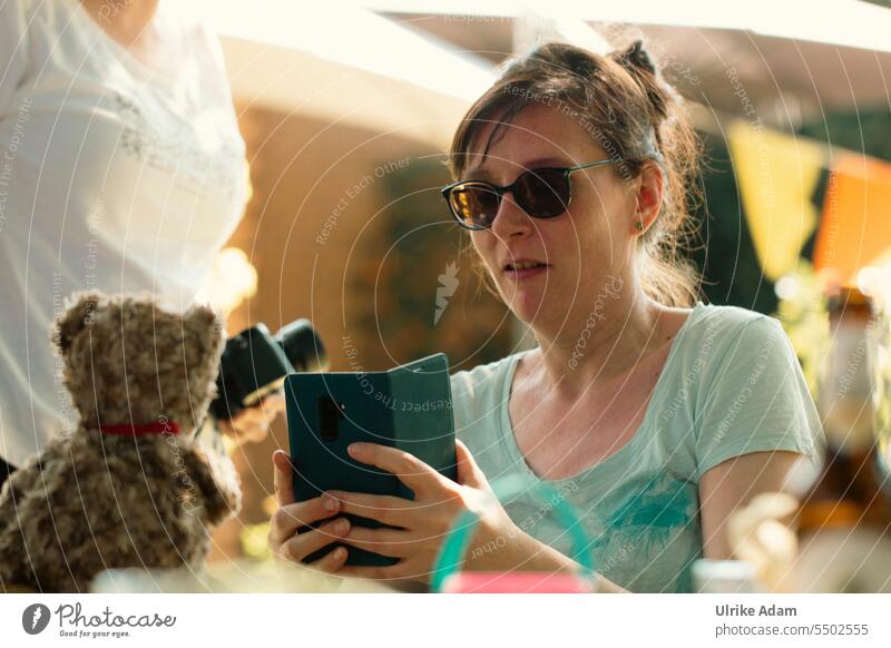 Drinkje bej Inkje | Foto-Shooting mit Otto - Frau fotografiert mit dem Smartphone einen Teddybär Freundlichkeit Oberkörper natürlich Optimismus lachen