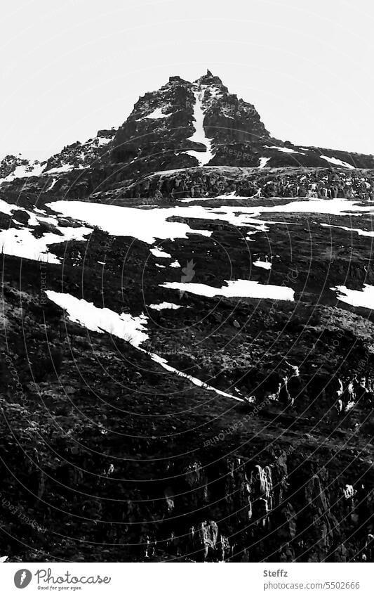 ein Berggipfel auf Island isländisch Gipfel Felswand Islandbild Ostisland Bergwand Bergseite Hügelseite Kälte Felsformation Schneeschmelze Formen schwarzweiß