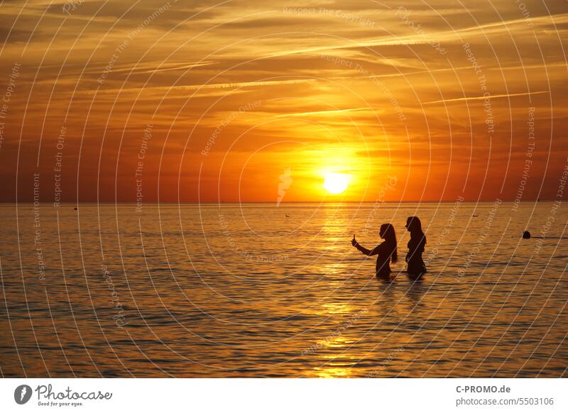 Frauen machen Selfis vor Sonnenuntergang selfie Handy freundinnen meer Ostsee Abendrot Horizont freunde Urlaubsfoto soziale medien