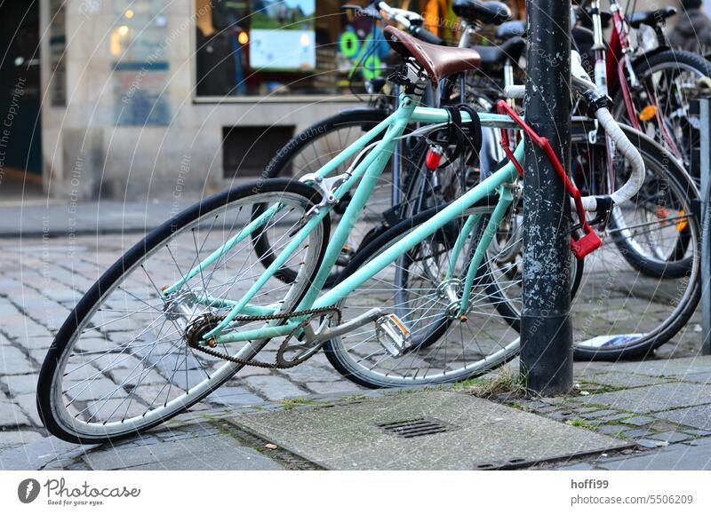 schnittiges Stadtrad in Schräglage an Laternenpfahl stadtrad Rad Radfahren abgeschlossen Lifestyle Fahrradfahren Verkehr Verkehrsmittel Reifen trendy Mobilität