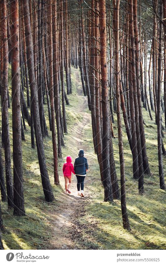 Sommerurlaub in der Natur. Familie beim Spaziergang im Wald. Menschen verbringen aktiv ihre Freizeit. Frau mit Tochter genießen langen Spaziergang während der Sommerzeit
