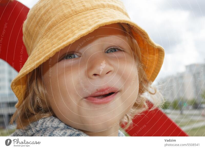 Lustiger glücklicher kleiner Junge in einem gelben Panama auf der Straße, Nahaufnahme Gesicht. Familie Menschen Kinder Kaukasier Spaziergang 2-4 Jahre alt