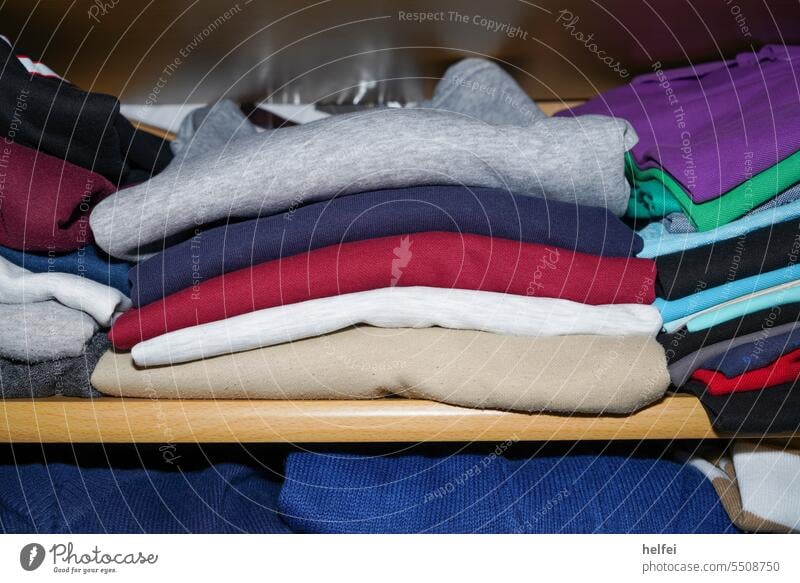 Blick in den Kleiderschrank, bunte Pullover und T-Shirts zusammengelegt Bekleidung hängen Stoff Kleidung Kleiderbügel Ordnung Kleidungsstück Textil Hemd Outfit