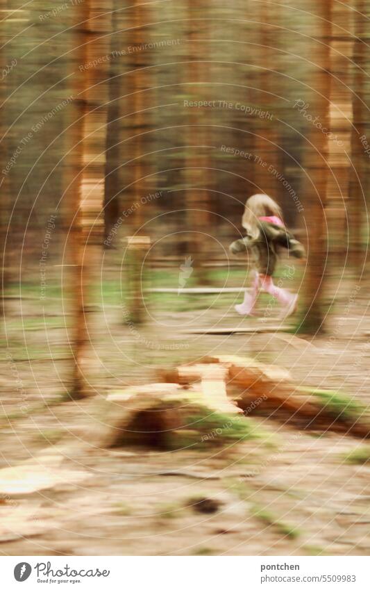 ein kind läuft durch einen wald. verschwommen, bewegungsunschärfe weglaufen spiel flucht gefahr bäume spaß mädchen Freizeit Kindheit Freude im Freien heiter