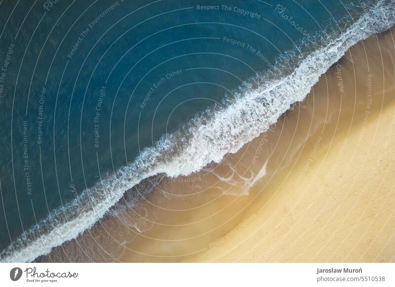Luftaufnahme der Ostseeküste mit Wellen, die den Sandstrand während des Sonnenaufgangs am Morgen zermalmen, Drohnenfotografie keine Menschen im Freien