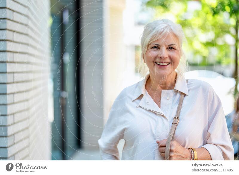 Porträt einer glücklichen älteren Frau in der Stadt Menschen Kaukasier Stehen Gesundheit Stadtleben graues Haar genießen Straße lässig Tag außerhalb