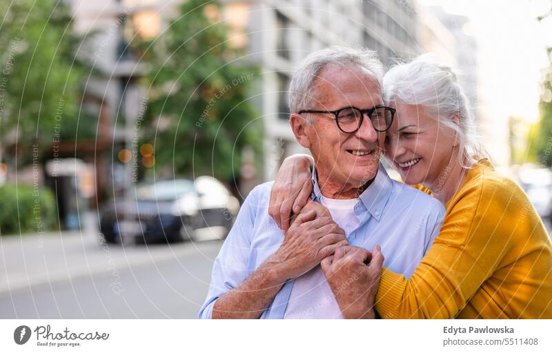 Porträt eines glücklichen älteren Paares, das sich in der Stadt umarmt Menschen Kaukasier Stehen Gesundheit Stadtleben graues Haar genießen Straße lässig Tag