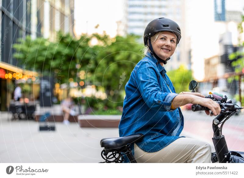 Porträt einer älteren Frau mit Helm beim Fahrradfahren in der Stadt Menschen Kaukasier Stehen Gesundheit Stadtleben graues Haar genießen Straße lässig Tag