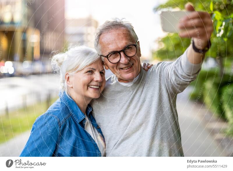 Älteres Paar nutzt Smartphone in der Stadt Menschen Stehen Gesundheit Stadtleben graues Haar genießen Straße lässig Tag Porträt außerhalb echte Menschen