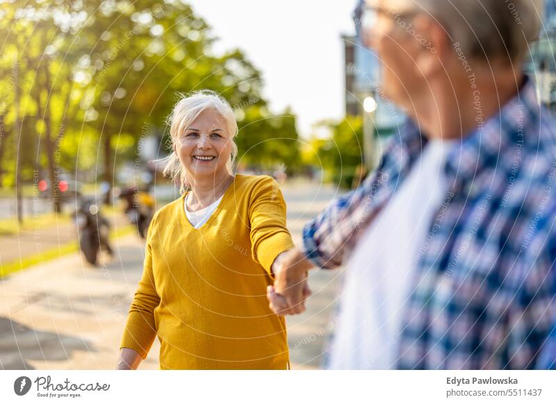 Verliebtes älteres Paar beim Spaziergang in der Stadt Menschen Kaukasier Stehen Gesundheit Stadtleben graues Haar genießen Straße lässig Tag Porträt außerhalb