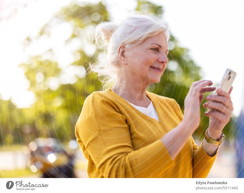 Ältere Frau benutzt Smartphone im Freien Menschen Kaukasier Stehen Gesundheit Stadtleben graues Haar genießen Straße lässig Tag Porträt außerhalb echte Menschen
