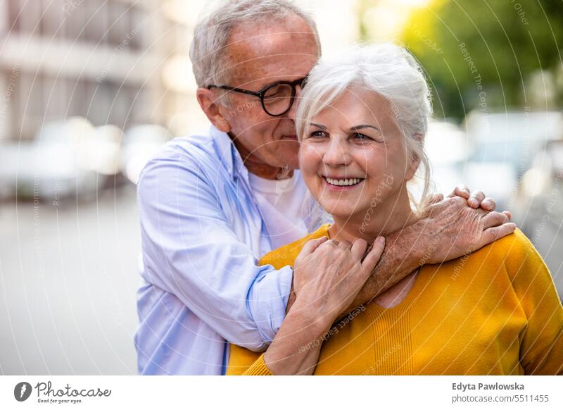 Porträt eines glücklichen älteren Paares, das sich in der Stadt umarmt Menschen Kaukasier Stehen Gesundheit Stadtleben graues Haar genießen Straße lässig Tag