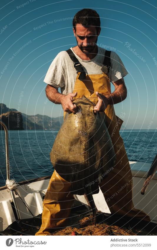 Hispanischer Fischer mit Rochen auf Boot Mann Schwimmer hispanisch Fischen MEER Sommer Fokus Natur Wasser Gefäße männlich Spanien Soller Mallorca marin Verkehr
