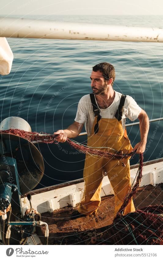 Fischer, der vom Segelboot aus im offenen Meer fischt Boot MEER Fischen Netz Schoner Arbeit Uniform Fokus männlich Soller Balearen Mallorca Wadenfisch jagen
