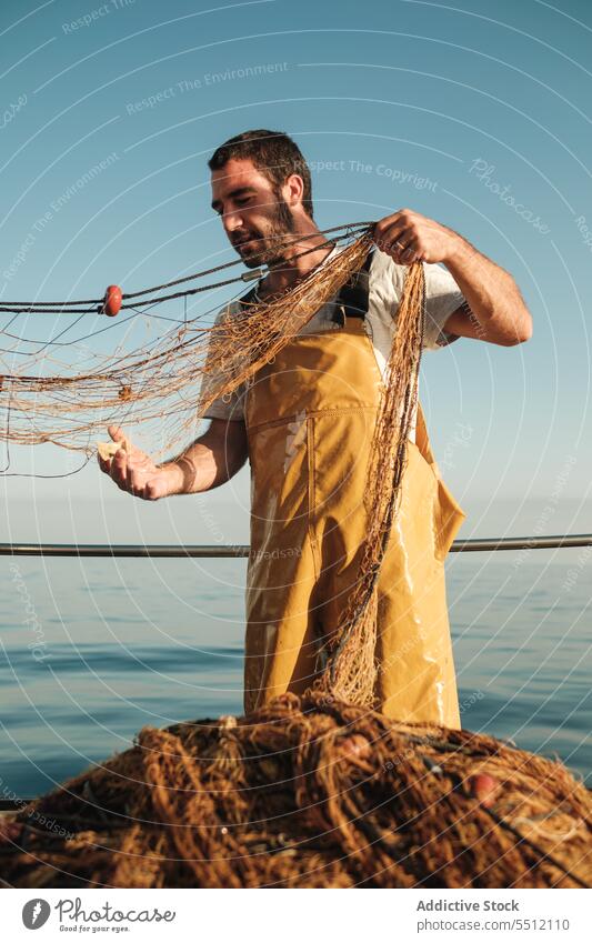 Fischer, der vom Segelboot aus im offenen Meer fischt Boot MEER Fischen Netz Schoner Arbeit Uniform männlich Soller Balearen Mallorca Wadenfisch Fokus jagen