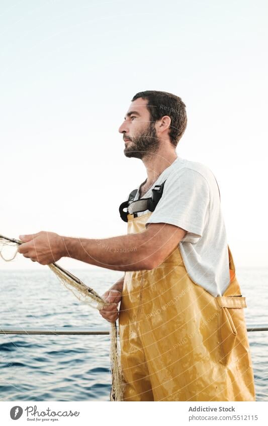 Fischer, der vom Segelboot aus im offenen Meer fischt Boot MEER Fischen Netz Schoner Arbeit Uniform Fokus männlich Soller Balearen Mallorca Wadenfisch jagen