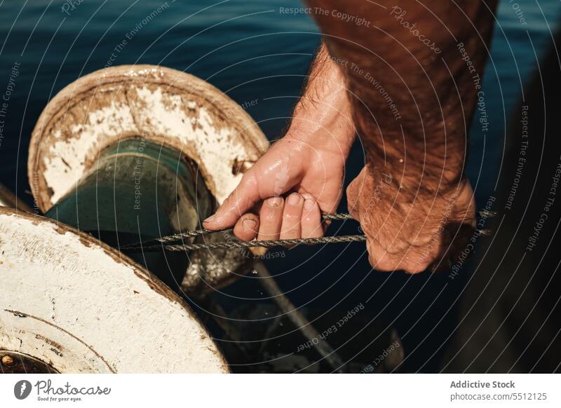 Kropfenmann zieht Fisch aus dem Meer Mann Wasser Rolle ziehen MEER Seil Fischer Fischen marin männlich Soller Spanien Mallorca fangen Gerät aqua Prozess