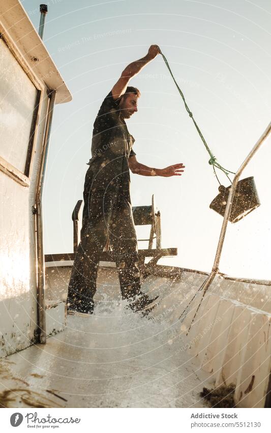 Seemann reinigt Deck eines Fischerbootes Fischen Boot Schoner Sauberkeit eingießen Wasser Eimer Schiffsdeck männlich Soller Balearen Mallorca Matrosen Tradition