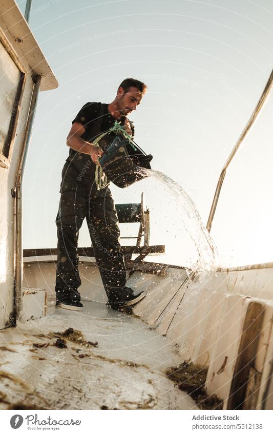 Seemann reinigt Deck eines Fischerbootes Fischen Boot Schoner Sauberkeit eingießen Wasser Eimer Schiffsdeck männlich Soller Balearen Mallorca Matrosen Tradition