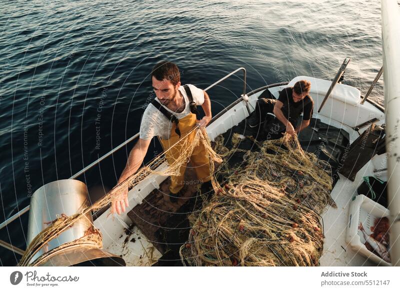 Fischer knüpft Netz auf Segelboot im Meer auf - ein lizenzfreies Stock Foto  von Photocase