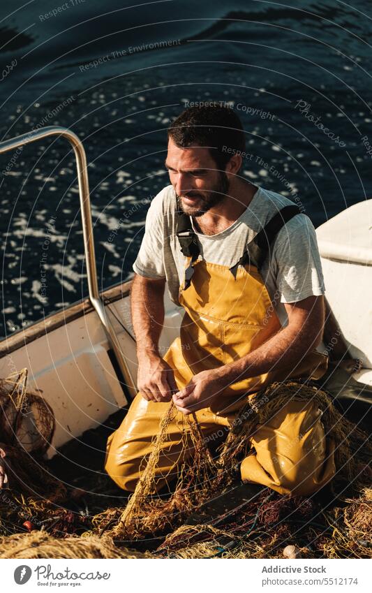 Fischer knüpft Netz auf Segelboot im Meer auf Arbeiter fangen Tradition Fischen aufbinden Boot Trawler männlich Soller Balearen Mallorca Matrosen Seemann