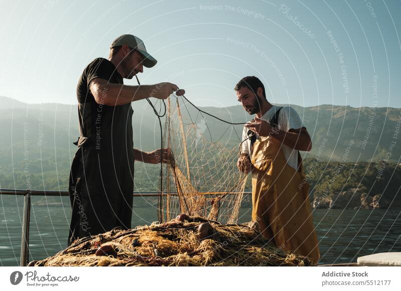 Hispanische Männer beim Fischen mit Netzen MEER Wasser fangen Gerät Sommer ernst männlich Soller Baleareninsel Mallorca Natur Umwelt marin aqua hispanisch