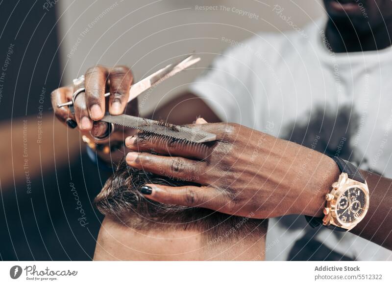 Schwarzer Friseur, der die Haare eines Kunden mit einer Schere schneidet Männer Klient geschnitten Kamm Haarschnitt Barbershop Behaarung Job jung männlich