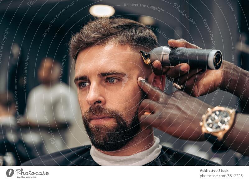 Friseur, der das Haar eines männlichen Kunden trimmt Männer Klient Haarschnitt entgittern Behaarung Trimmer Barbershop Genauigkeit Schönheit jung