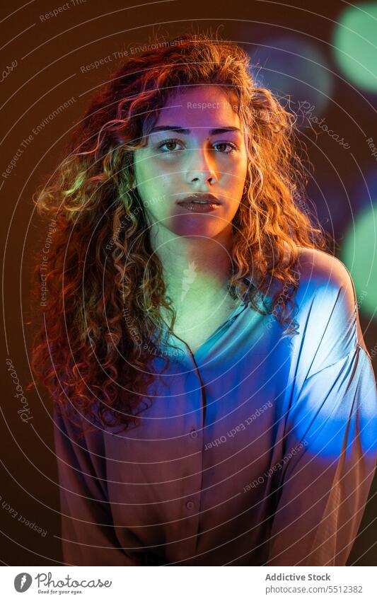 Attraktive Frau in einem Raum mit Neonröhren Porträt krause Haare Einfluss leuchten neonfarbig Punkt Windstille friedlich ruhig sinnlich jung Dame lange Haare