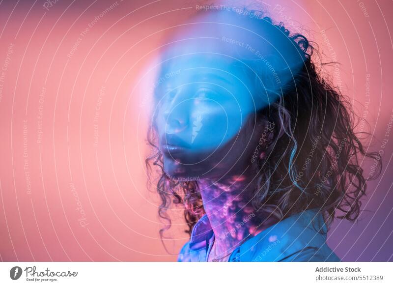 Attraktive Frau mit lockigem Haar in einem Raum mit Neonlicht Porträt krause Haare Einfluss leuchten Punkt Windstille friedlich ruhig sinnlich jung Dame