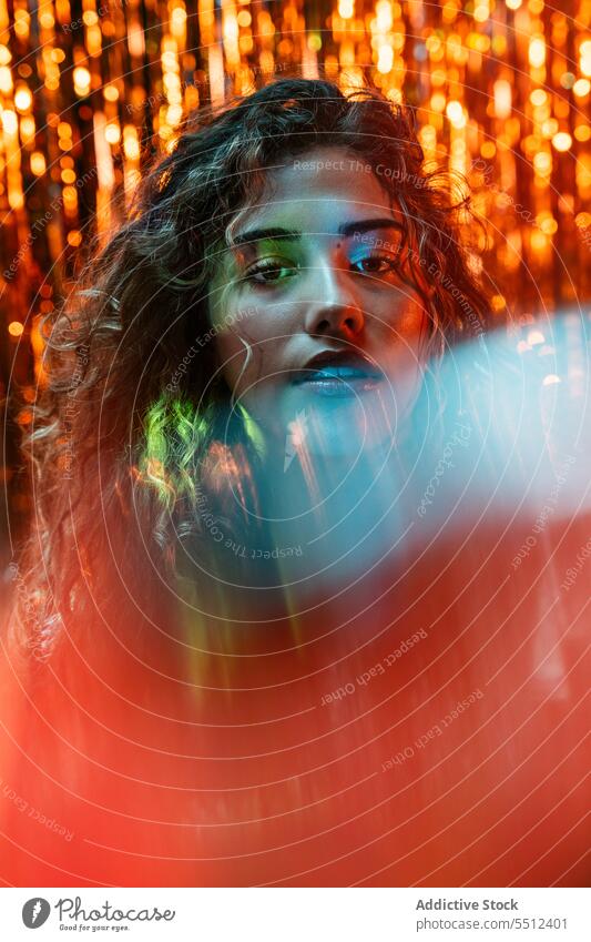 Attraktive Frau mit lockigem Haar in einem Raum mit Neonlicht Porträt krause Haare Einfluss leuchten Punkt Windstille friedlich ruhig sinnlich jung Dame