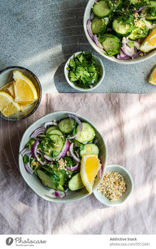 Ansicht von oben auf gesunde Gemüsesalate Salatbeilage organisch Gewürz Salatgurke Vegetarier Schalen & Schüsseln Zwiebel Kraut Paprika Zitrone Murmel mischen