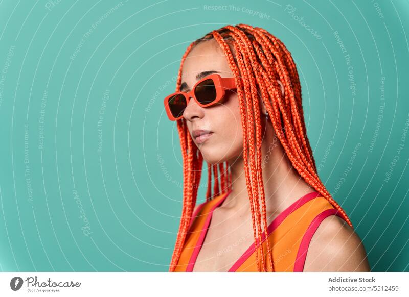 Stylische Frau in orangefarbenem Outfit und Sonnenbrille selbstbewusst stylisch Mode Model Porträt Studioaufnahme emotionslos cool lebhaft Vorschein Kaukasier
