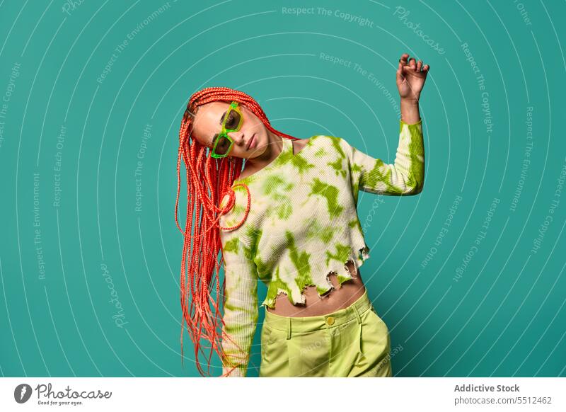 Stylische Frau tanzt in grünem Outfit und Sonnenbrille selbstbewusst stylisch Mode Model Bewegung Studioaufnahme emotionslos Tanzen cool lebhaft Vorschein jung