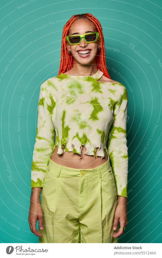 Stilvolle glückliche Frau in grünem Outfit und Sonnenbrille selbstbewusst stylisch Mode Model Studioaufnahme Lächeln cool lebhaft Glück heiter Vorschein jung