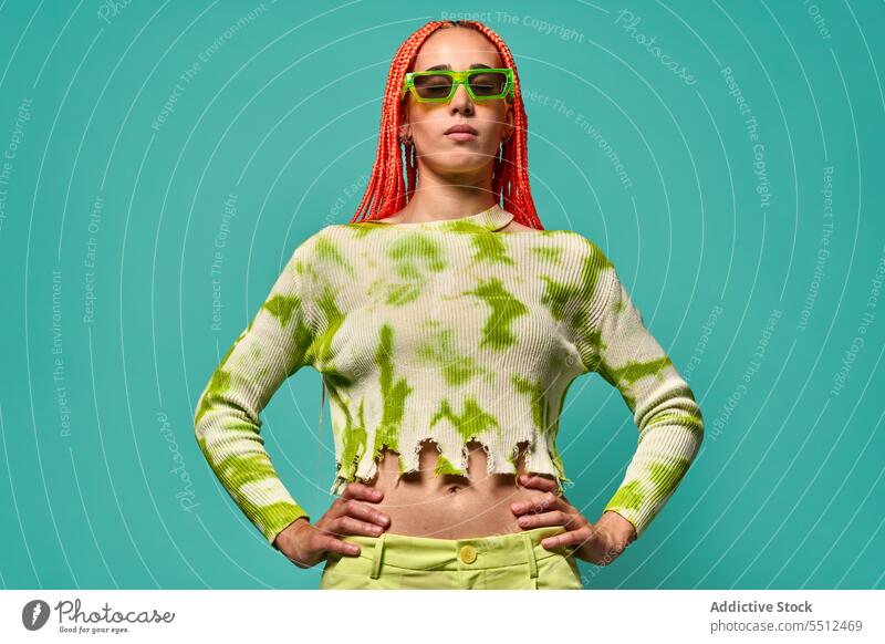 Stilvolle Frau in grünem Outfit und Sonnenbrille selbstbewusst stylisch Mode Model Studioaufnahme emotionslos cool lebhaft Vorschein jung Afro-Zöpfe Langarm Top