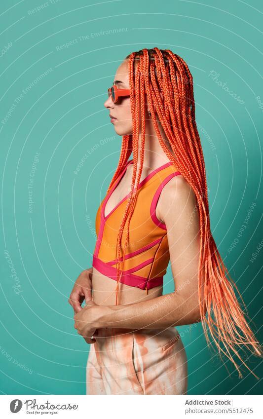 Stylische Frau in orangefarbenem Outfit und Sonnenbrille selbstbewusst stylisch Mode Model Porträt Studioaufnahme emotionslos cool lebhaft Vorschein Kaukasier