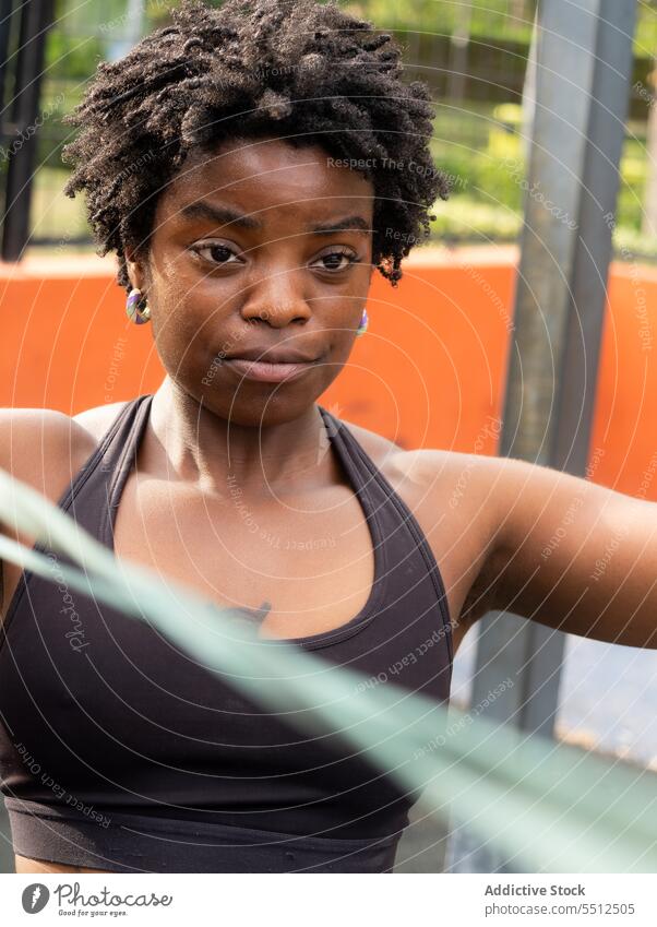 Porträt einer ethnischen Sportlerin, die auf dem Boden einer Turnhalle mit Bändern trainiert Athlet Training Wellness Fitness stark Fitnessstudio Frau jung