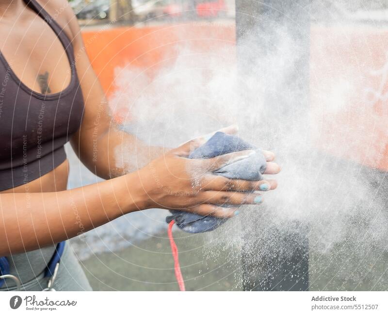 Nicht erkennbare junge ethnische Frau, die Kreidepulver mit den Händen abstreicht Pulver Sack Staubwischen Hand vorbereiten Training Athlet Talkum Wellness