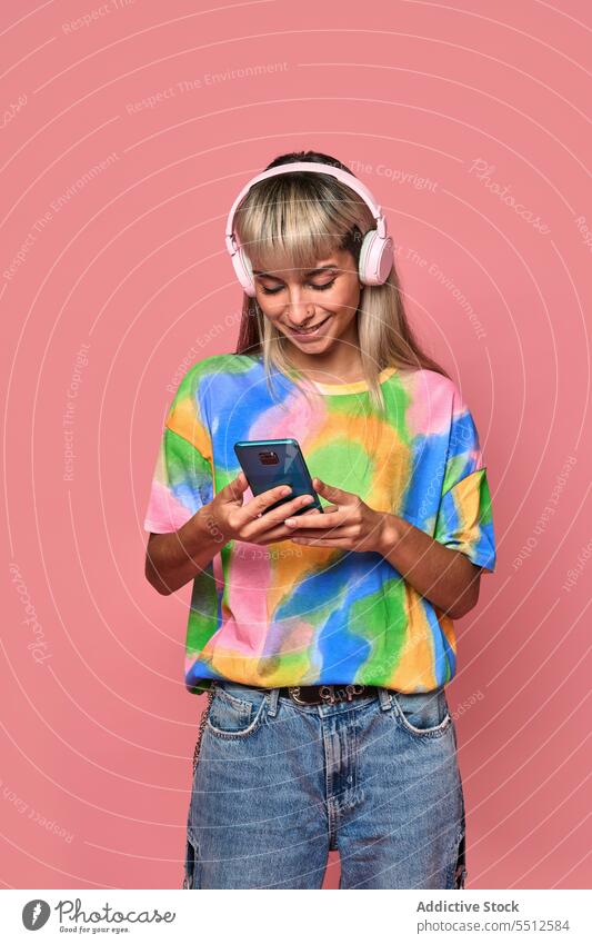 Junge Hipsterin benutzt Smartphone im Studio Frau benutzend Surfen Internet Kopfhörer Studioaufnahme Piercing Nachricht jung blond Lächeln trendy Streetstyle