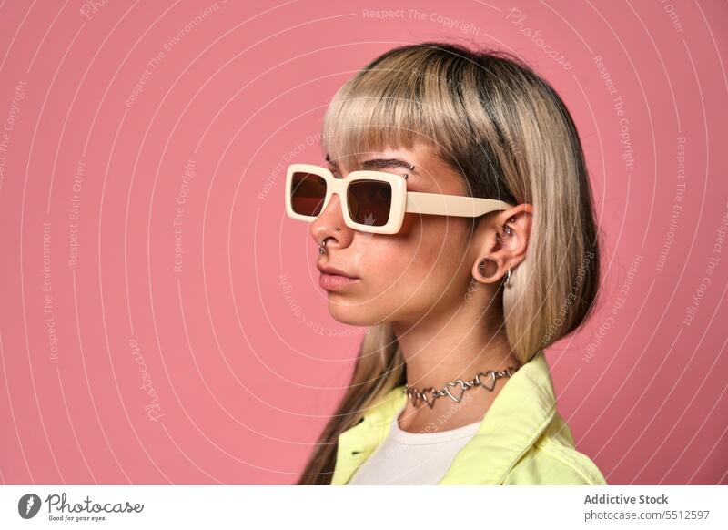 Trendiges weibliches Modell mit Sonnenbrille Frau trendy Körperhaltung Studioaufnahme Porträt Piercing selbstbewusst selbstsicher cool emotionslos jung Stil