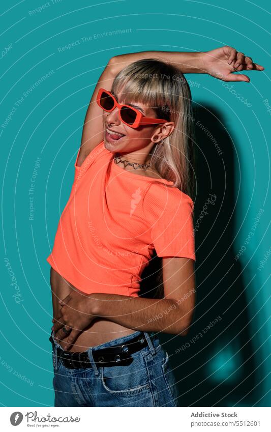 Selbstbewusste, glückliche, trendige Hipster-Frau mit Sonnenbrille Hand auf Kopf Lächeln trendy Streetstyle Körperhaltung Studioaufnahme Glück informell