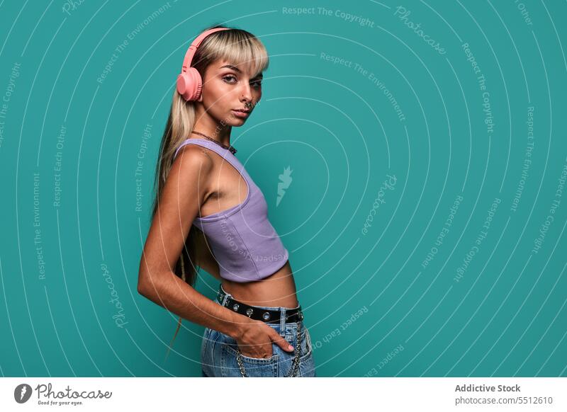 Junge Frau hört Musik im Studio Kopfhörer zuhören Gesang Studioaufnahme Wiedergabeliste Freizeit meloman jung blond lässig Stil Top Jeanshose Pony Model