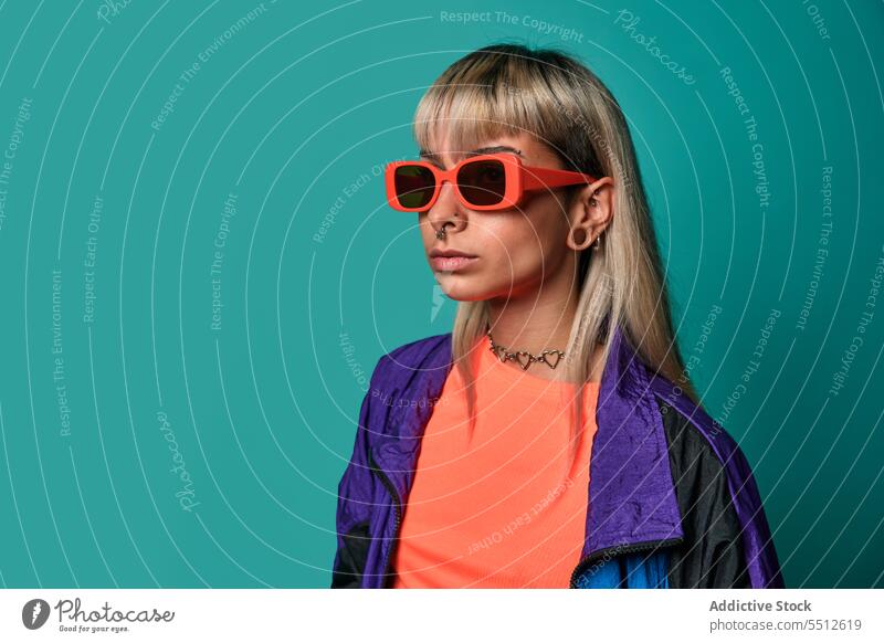 Selbstbewusste trendige Hipster-Frau mit Sonnenbrille trendy Streetstyle Körperhaltung Studioaufnahme informell Subkultur selbstbewusst selbstsicher emotionslos