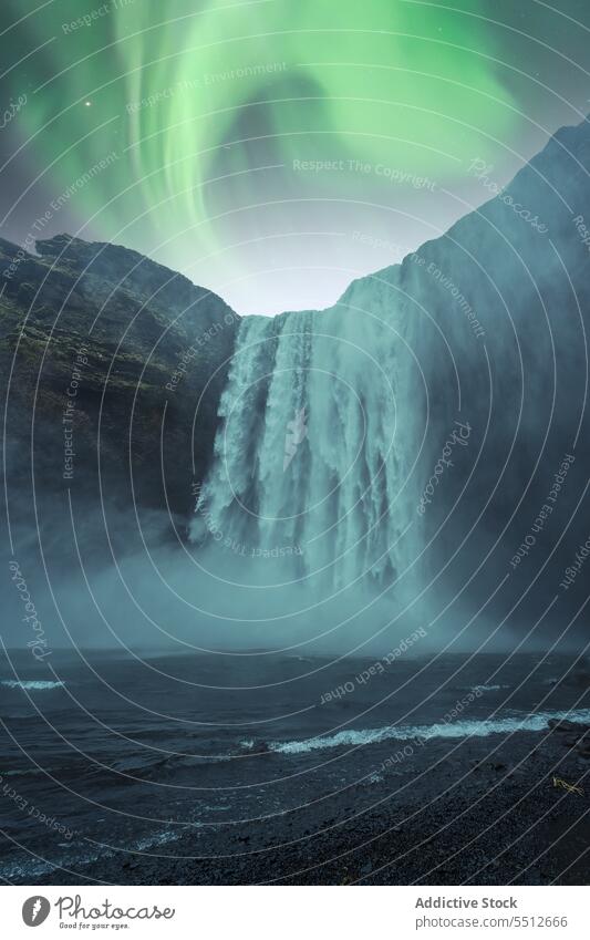 Mächtiger Wasserfall fließt durch felsigen Hang unter Nordlicht Landschaft Berge u. Gebirge Berghang polar Aurora Erscheinung majestätisch Island Europa wild