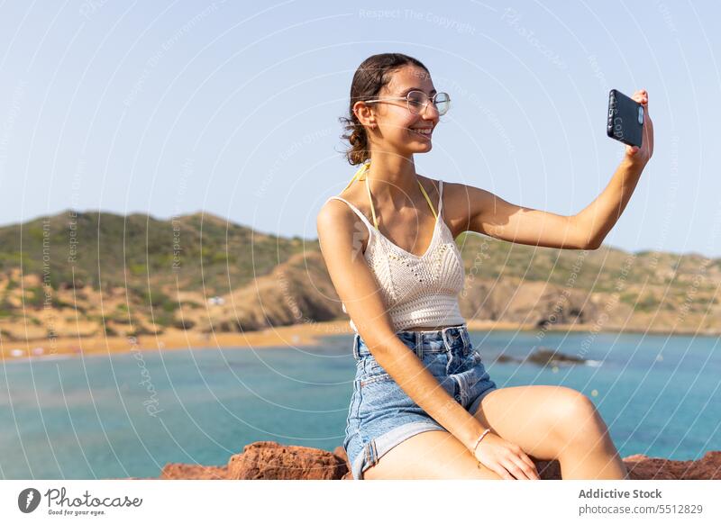 Glückliche Frau, die ein Selfie mit ihrem Smartphone macht MEER Sommer Telefon Wasser heiter Lächeln Mobile jung Gerät Brille Apparatur Fotografie positiv