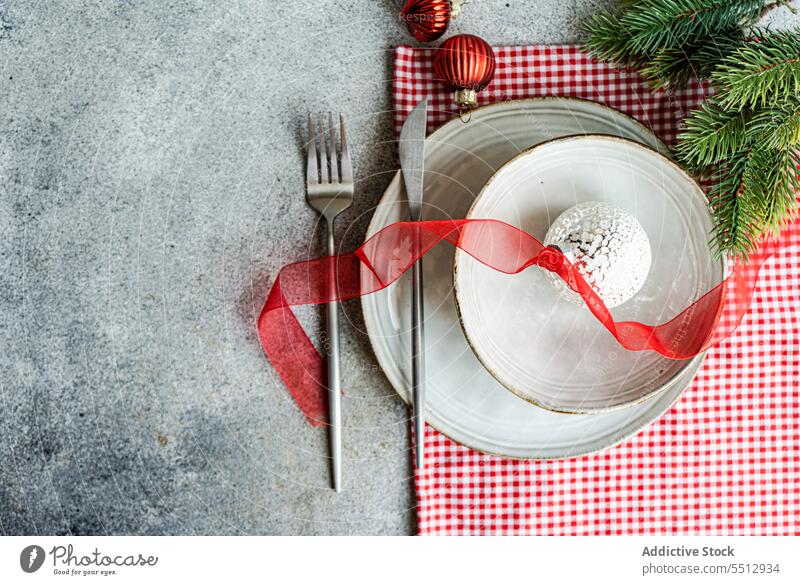 Utensil auf dem Tisch in der Nähe von Tannenzweigen aus Nadelholz Weihnachten Teller Gabel Messer Bändchen Ball Dekoration & Verzierung Feiertag Besteck feiern