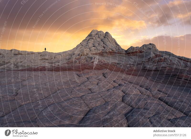 Anonymer Reisender bei Sonnenuntergang auf einem Stein stehend Berge u. Gebirge Gelände Felsbrocken Himmel wolkig Silhouette erkunden Natur Landschaft Abenteuer