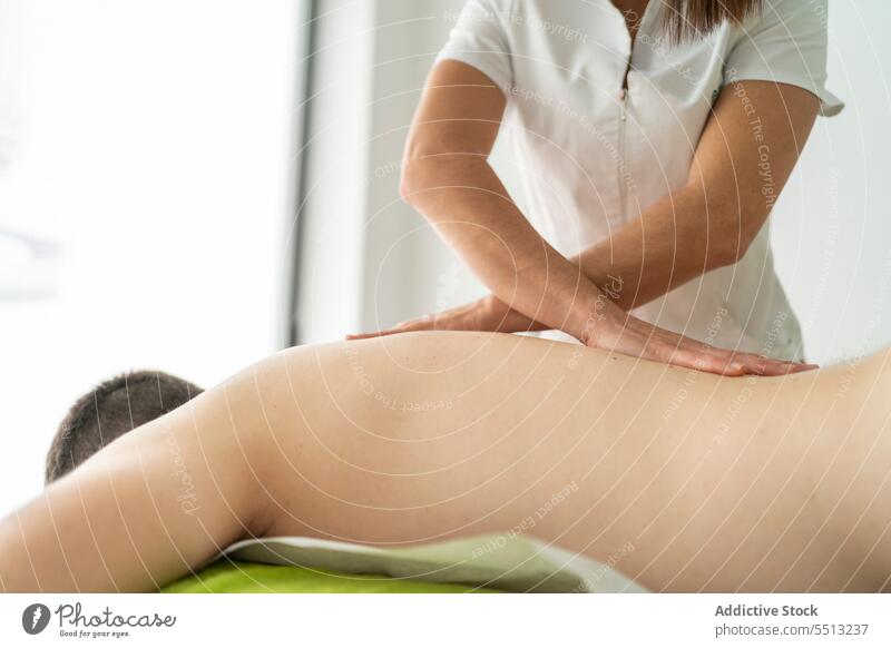 Unkenntlich gemachter Therapeut massiert Rücken eines Patienten Frau Massage geduldig Masseurin Osteopathie Physiotherapie Klinik Rehabilitation Verfahren