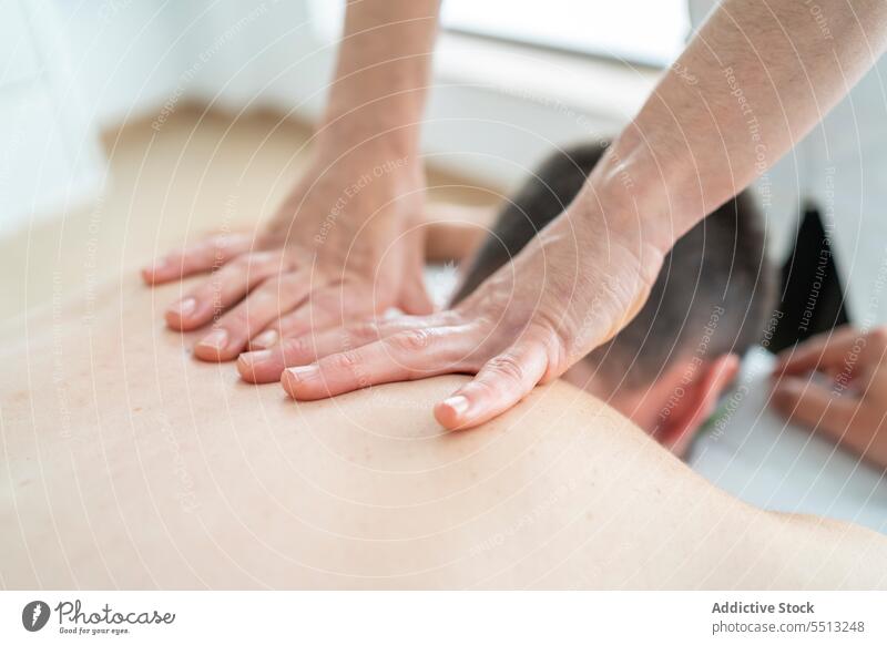 Anonymer Massagetherapeut massiert den Nacken eines Patienten Mann Therapie Osteopathie geduldig Masseur Physiotherapie Therapeut Leckerbissen Verfahren Presse